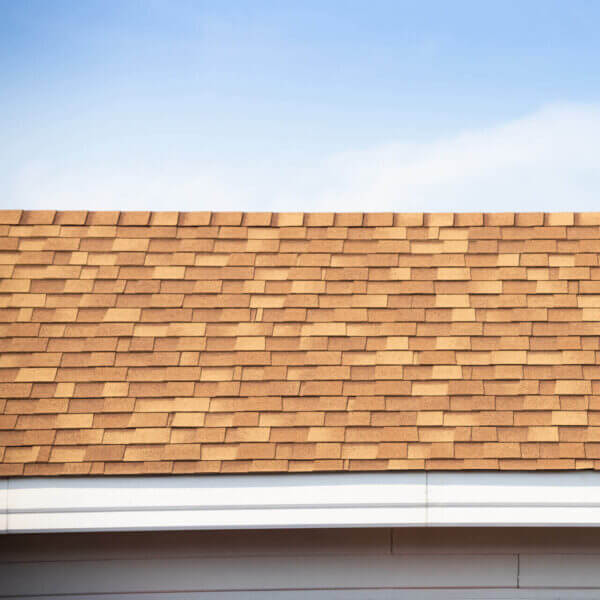Brown Roof Shingle And Blue Sky. Asphalt Tiles On The Roof